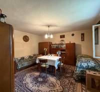 Predaj domu v Janovej Lehote - Obývacia izba s kobercom, dreveným nábytkom a stolom v rodinnom dome.