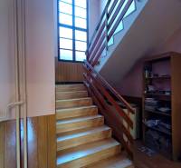 : Predaj rodinného domu s veľkým pozemkom v obci Pitelová  - Podlaha s dreveným dekorom a schodisko s oknom v Rodinnom dome.