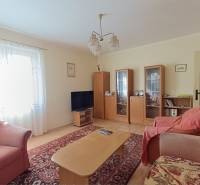 : Predaj rodinného domu s veľkým pozemkom v obci Pitelová  - Obývacia izba s dreveným dekorom, pohovkou, televízorom a vitrínami v Rodinnom dome.