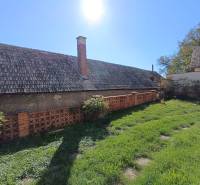 : Predaj rodinného domu s veľkým pozemkom v obci Pitelová  - Rodinný dom v Pitelovej so záhradou, tehlovým plotom a šikmou strechou.