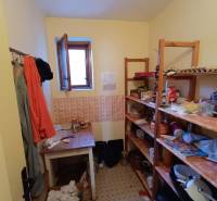 : Predaj rodinného domu s veľkým pozemkom v obci Pitelová  - Špajza v rodinnom dome s policami a oknom, rôzne uskladnené predmety a potraviny.