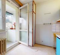 RADO I 2 IZBOVY BYT s loggiou I Adámiho ul. KARLOVA VES - Kuchyňa s bielymi skrinkami, svetlom a výhľadom na balkón v 2-izbovom byte.