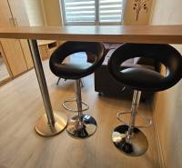 TOPOĽĆANY - zariadená garsónka na sídlisku JUH - Garsónka s pultom, stoličkami a podlahou s dreveným dekorom.