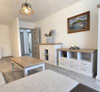 Moderný 2-izbový byt po rekonštrukcii v srdci Zlatého potoka - Zvolen - Obývačka v 2-izbovom byte so svetlým nábytkom a podlahou s dreveným dekorom.