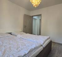 Moderný 2-izbový byt po rekonštrukcii v srdci Zlatého potoka - Zvolen - Spálňa v 2-izbovom byte s dvojlôžkom, svetlou stenou a podlahou s dreveným dekorom.