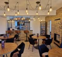 Prenájom kaviarne  v obci Nová Dedinka pri Senci - Gastro priestory s podlahou s dreveným dekorom a závesnými žiarovkami.