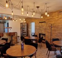 Prenájom kaviarne  v obci Nová Dedinka pri Senci - Gastro priestory s visiacimi svetlami, dreveným dekorom a útulným sedením.