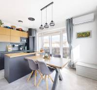 RADO I 3-izbový byt 84 m2 + terasa 13 m2 + parking I Veľký Biel- Senec - Kuchyňa v 3-izbovom byte s podlahou s dreveným dekorom, jedálenským stolom a modernou klimatizáciou.
