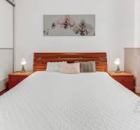  VÝNIMOČNÝ 4-izbový byt rozdelený na DVA SAMOSTATNÉ BYTY - Spálňa s podlahou s dreveným dekorom, posteľou, obrazom a skriňou v 4-izbovom byte.