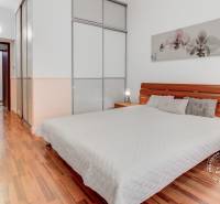  VÝNIMOČNÝ 4-izbový byt rozdelený na DVA SAMOSTATNÉ BYTY - Spálňa s posteľou, šatníkovou skriňou a podlahou s dreveným dekorom v 4-izbovom byte.