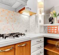  VÝNIMOČNÝ 4-izbový byt rozdelený na DVA SAMOSTATNÉ BYTY - Kuchyňa v 4-izbovom byte s plynovým sporákom, dlaždicami a barovým pultom s kvetmi.