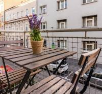  VÝNIMOČNÝ 4-izbový byt rozdelený na DVA SAMOSTATNÉ BYTY - Balkón 4-izbového bytu na Grösslingovej ulici v Bratislave, so stolom a stoličkami.