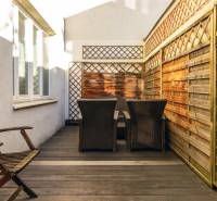  VÝNIMOČNÝ 4-izbový byt rozdelený na DVA SAMOSTATNÉ BYTY - Terasa s drevenými prvkami a vonkajším nábytkom v 4-izbovom byte.