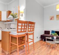  VÝNIMOČNÝ 4-izbový byt rozdelený na DVA SAMOSTATNÉ BYTY - Kuchyňa s barovým pultom a obývačka v 4-izbovom byte, podlaha s dreveným dekorom.