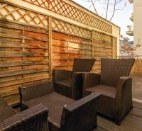  VÝNIMOČNÝ 4-izbový byt rozdelený na DVA SAMOSTATNÉ BYTY - Terasa so záhradným nábytkom v 4-izbovom byte, podlaha s dreveným dekorom.