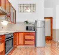  VÝNIMOČNÝ 4-izbový byt rozdelený na DVA SAMOSTATNÉ BYTY - Kuchyňa v 4-izbovom byte s podlahou s dreveným dekorom a drevenými skrinkami.