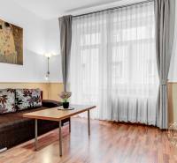  VÝNIMOČNÝ 4-izbový byt rozdelený na DVA SAMOSTATNÉ BYTY - Obývacia izba s pohovkou, televízorom a podlahou s dreveným dekorom v 4-izbovom byte.