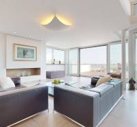 Exkluzívny byt pod Slavínom s terasou a výhľadom na Bratislavu - Svetlá obývacia izba so sedačkami a výhľadom v 4-izbovom byte.