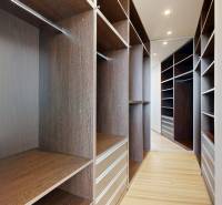 Exkluzívny byt pod Slavínom s terasou a výhľadom na Bratislavu - Šatník s hnedými skrinkami a podlahou s dreveným dekorom v 4-izbovom byte.