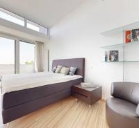 Exkluzívny byt pod Slavínom s terasou a výhľadom na Bratislavu - Svetlá spálňa s veľkými oknami a podlahou s dreveným dekorom v 4-izbovom byte.