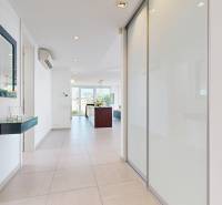 Exkluzívny byt pod Slavínom s terasou a výhľadom na Bratislavu - Interiér 4-izbového bytu s bielymi stenami a veľkými zrkadlovými skrinkami.