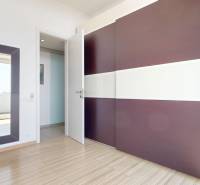 Exkluzívny byt pod Slavínom s terasou a výhľadom na Bratislavu - Šatník s veľkým zrkadlom a podlahou s dreveným dekorom v 4-izbovom byte.