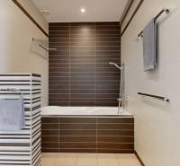 Exkluzívny byt pod Slavínom s terasou a výhľadom na Bratislavu - Kúpeľňa s vaňou a hnedými dlaždicami vo 4-izbovom byte.