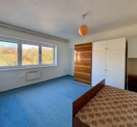 Rodinný dom v obci Šarišské Čierne okr. Bardejov - ZNÍŽENÁ CENA - Spálňa v rodinnom dome s modrým kobercom, skrinkami a veľkými oknami.