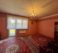 Rodinný dom v obci Šarišské Čierne okr. Bardejov - ZNÍŽENÁ CENA - Obývačka v rodinnom dome s červeným kobercom, jednoduchými záclonami a svetlom.