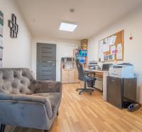 MODERNÝ KANCELÁRSKY PRIESTOR NA PRENÁJOM - Kancelária s podlahou s dreveným dekorom, pohodlným kreslom a pracovným stolom.