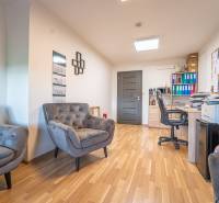 MODERNÝ KANCELÁRSKY PRIESTOR NA PRENÁJOM - Interiér kancelárie s podlahou s dreveným dekorom, pohodlnými kreslami a pracovným stolom.