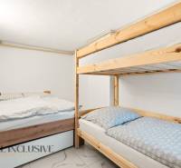 NADŠTANDARDNÁ REKREAČNÁ CHATA | DUCHONKA  - Spálňa v chate s poschodovou posteľou a ďalším lôžkom, podlahou s dreveným dekorom.