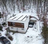 NADŠTANDARDNÁ REKREAČNÁ CHATA | DUCHONKA  - Chata na ulici Duchonka v Prašiciach, zasnežený les v pozadí, zaparkované autá.