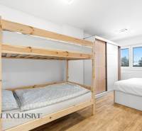 NADŠTANDARDNÁ REKREAČNÁ CHATA | DUCHONKA  - Interiér chaty s poschodovými posteľami, skriňou a podlahou s dreveným dekorom.