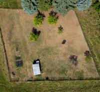 Predaj pozemok Banská Belá - Letecký pohľad na pozemok určený na bývanie v Banskej Belej s trávnatou plochou a stromami.