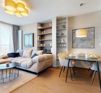 RIVERS | Butikovo zariadený ateliér na 32. poschodí Eurovea Tower - Obývacia izba s pohodlnou sedačkou, jedálenským stolom a podlahou s dreveným dekorom.