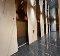 RIVERS | Butikovo zariadený ateliér na 32. poschodí Eurovea Tower - Elegantná vstupná hala s výťahmi a lesklou podlahou s dreveným dekorom.