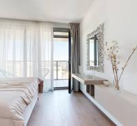 RIVERS | Butikovo zariadený ateliér na 32. poschodí Eurovea Tower - Svetlá spálňa s podlahou s dreveným dekorom v 2-izbovom byte, s výhľadom na balkón.