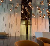 RIVERS | Butikovo zariadený ateliér na 32. poschodí Eurovea Tower - Interiér s oddychovou zónou, závesnými svietidlami a podlahou s dreveným dekorom.