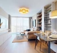 RIVERS | Butikovo zariadený ateliér na 32. poschodí Eurovea Tower - Obývacia izba 2-izbového bytu s pohovkou, podlahou s dreveným dekorom a jedálenským stolom.