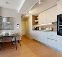 RIVERS | Butikovo zariadený ateliér na 32. poschodí Eurovea Tower - Kuchyňa a jedálenský kút v 2-izbovom byte, s podlahou s dreveným dekorom.