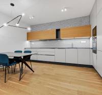 ︱ PREDAJ Nadštandardný 3-izb. byt v projekte Gansberg Koliba - Kuchyňa v 3-izbovom byte s jedálenským stolom, podlaha s dreveným dekorom.