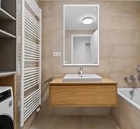 ︱ PREDAJ Nadštandardný 3-izb. byt v projekte Gansberg Koliba - Kúpeľňa s vaňou, umývadlom, zrkadlom a skrinkou v 3-izbovom byte.