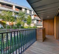 ︱ PREDAJ Nadštandardný 3-izb. byt v projekte Gansberg Koliba - Balkón 3-izbového bytu s výhľadom na zeleň, podlaha s dreveným dekorom.