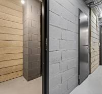 ︱ PREDAJ Nadštandardný 3-izb. byt v projekte Gansberg Koliba - Chodba so šedými a bielymi stenami, plechové dvere, miestnosť v pozadí.