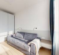 Elegantný byt na mieru s panorámou hradu  - Svetlá izba s pohovkou a podlahou s dreveným dekorom v 3-izbovom byte.