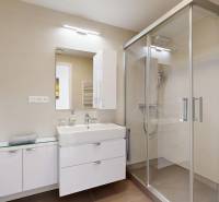 Elegantný byt na mieru s panorámou hradu  - Kúpeľňa v 3-izbovom byte so sprchovacím kútom, umývadlom a úložnými skrinkami.