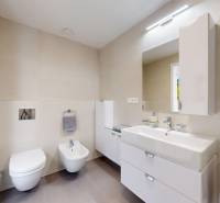 Elegantný byt na mieru s panorámou hradu  - Kúpeľňa v 3-izbovom byte s čistými líniami, svetlými obkladmi a dvojitým umývadlom.