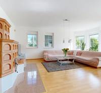 RIVERS - Veľkorysý rodinný dom po rekonštrukcii  - Obývačka v rodinnom dome s kachľami, pohovkou a podlahou s dreveným dekorom.