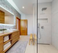 RIVERS - Veľkorysý rodinný dom po rekonštrukcii  - Kúpeľňa v rodinnom dome s umývadlami, sprchou a skrinkou s dreveným dekorom.